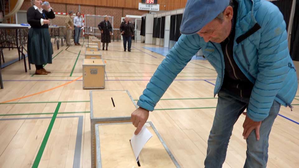 En mand lægger sin stemme i stemmeurnen.